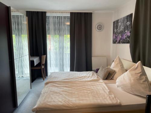 a bedroom with a white bed and a window at Hotel Restaurant Toscana in Bad Orb