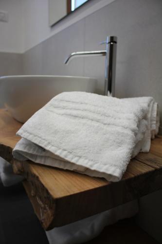 a towel sitting on top of a wooden table next to a bath tub at Il giardino in campagna in Seren del Grappa