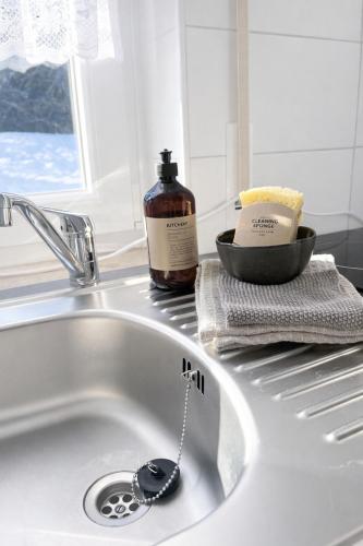 a sink with a bottle of soap sitting next to it at Ferienhaus Seeblick Westerwald in Mengerskirchen