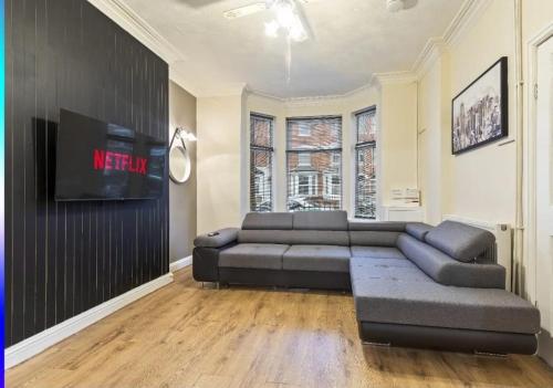 a living room with a couch and a flat screen tv at Large 5-Bed Home, Free Parking, Perfect for Groups in Nottingham