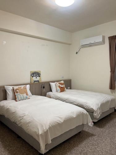 two beds sitting next to each other in a room at Pick Inn in Taitung City