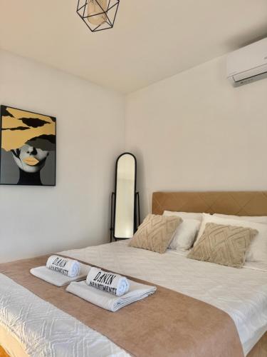 a bedroom with a large bed with two pillows on it at Danin apartmani in Bar