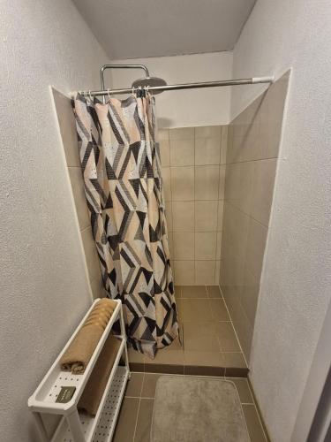 a shower in a bathroom with a shower curtain at Ozolkungi in Turaida