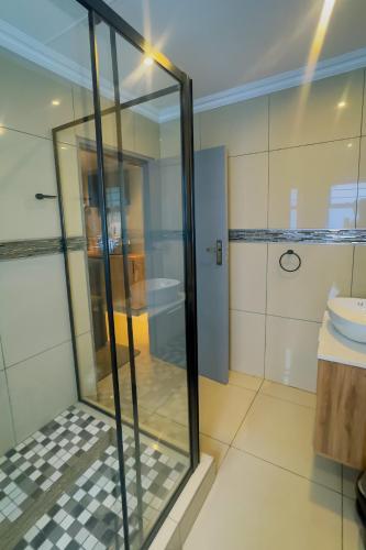 a bathroom with a glass shower and a toilet at The Hide on Aston-Sandton in Johannesburg