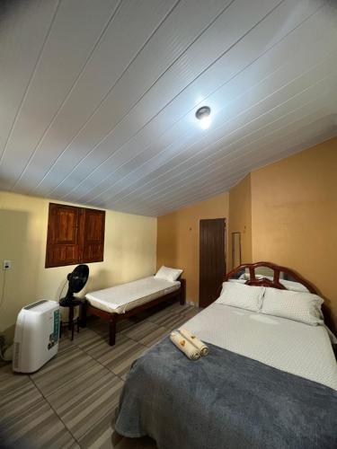 a bedroom with a bed and a bench in it at Pousada Maracajaú in Maracajaú