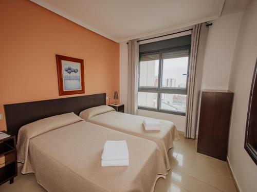 a bedroom with two beds and a large window at Apartamento Gema Gemelos 26 in Benidorm