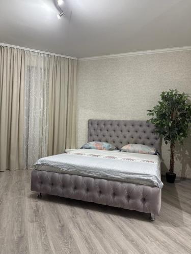 ein Schlafzimmer mit einem Bett mit gepolstertem Kopfteil in der Unterkunft Apartament in Chişinău