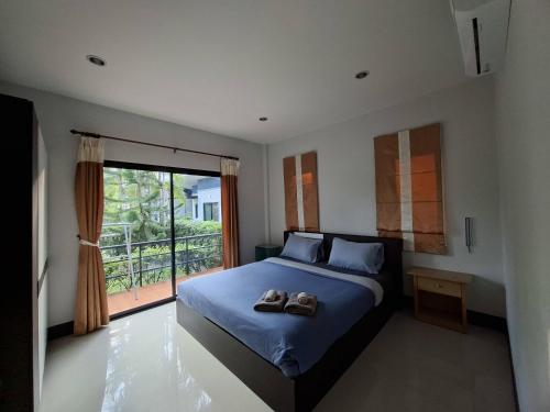 a bedroom with a bed with two shoes on it at Little Blue House- AoNang in Ao Nang 