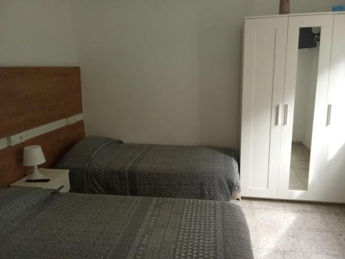 a bedroom with two beds and a mirror at Casa ADOLFO in Almáciga