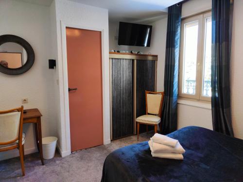 a hotel room with a bed and a window at Hotel Au Val Doré in La Bourboule