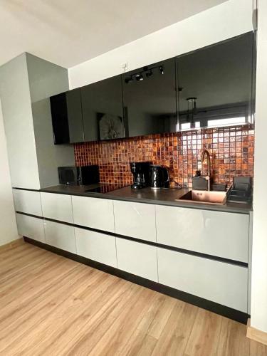 a kitchen with white cabinets and a sink at SPV Rentals Pileckiego 59 lokal 226 free Parking Ursynów in Warsaw