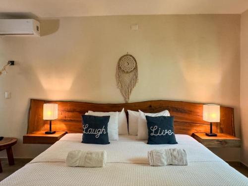 a bedroom with a large bed with two lamps at Esencia Valladolid Hotel in Valladolid