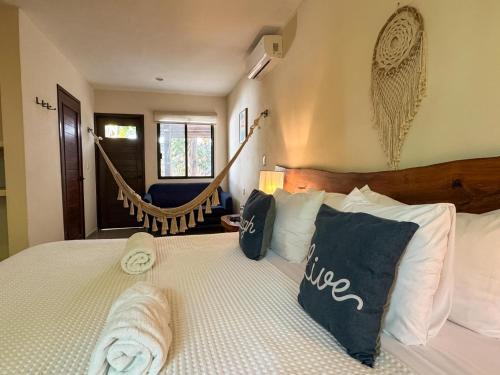 a bedroom with a bed with pillows and a hammock at Esencia Valladolid Hotel in Valladolid