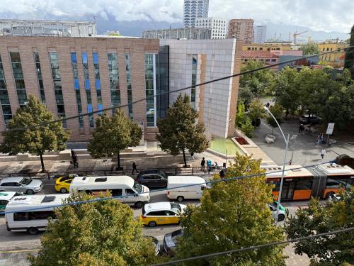una città con autobus e auto in un parcheggio di Prime Location - shared Bath a Tirana