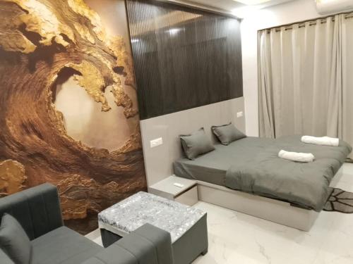 a bedroom with a bed and a couch and a chair at Kremlin Luxury Studios in Ghaziabad