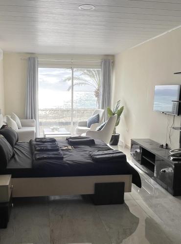 a bedroom with a large bed and a large window at voya hotel and suites in Soûr