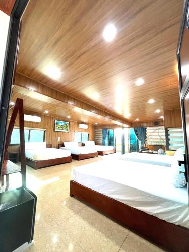 a large bedroom with two beds in a boat at Lona Villa Tam Coc in Vũ Lâm
