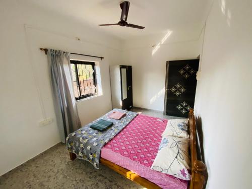 a bedroom with a bed with a pink blanket at HoneyBee 2BHK Homestay Agonda in Agonda
