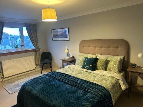 a bedroom with a large bed and a window at The Place in Johnshaven