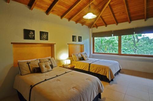 a bedroom with two beds and a large window at Argovia Finca Resort in Tapachula