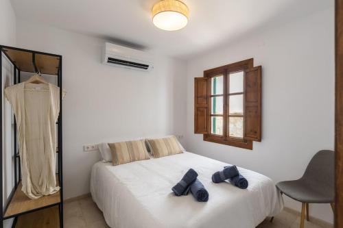 a bedroom with a white bed and a window and a chair at Ca Sa Joia - Beautiful Views in Port d'Andratx