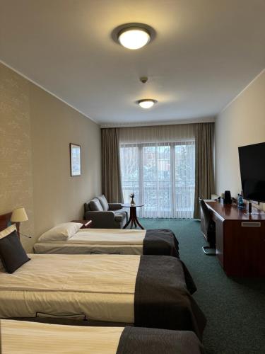 En eller flere senge i et værelse på Hotel Rigga
