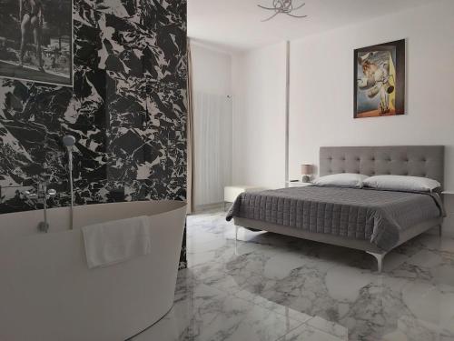 a bedroom with a large bed and a bath tub at Apartments Marini in Pordenone