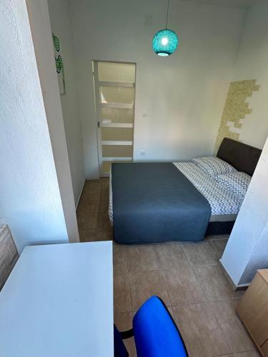 a small bedroom with a bed and a blue ottoman at Villa Nela in Tivat