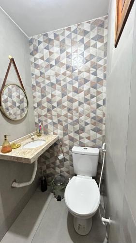 a bathroom with a white toilet and a sink at Casa Sophi in Cruz