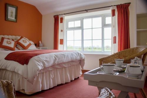a bedroom with a bed and a window and a table at Brambling Fields B&B and Cottages in Malton