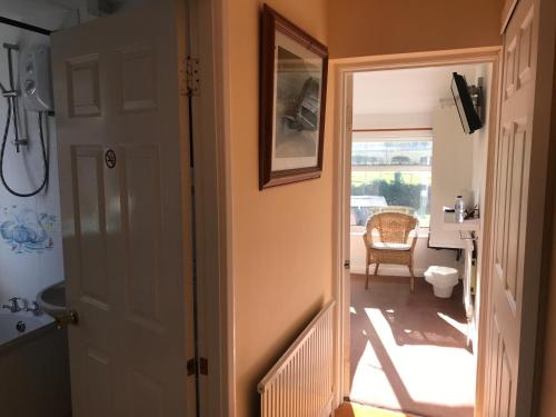 a hallway with a door leading to a bathroom at Brambling Fields B&B and Cottages in Malton
