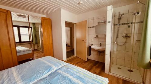 a bedroom with a bed and a shower and a sink at Ferienwohnungen Hoefchen in Eckfeld