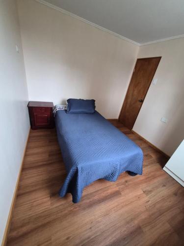 a bedroom with a bed with a blue blanket at Cabaña Alfalfares Oriente in La Serena