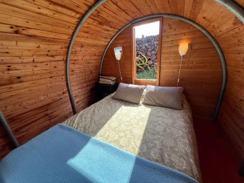 a bedroom with a bed in a wooden room at The Secret Garden Lanzarote in Haría