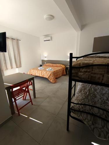 a room with two beds and a table and a desk at Villa Ranucci Formia guesthouse in Formia