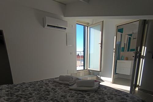 a bedroom with a bed and a large window at Villa Ranucci Formia guesthouse in Formia