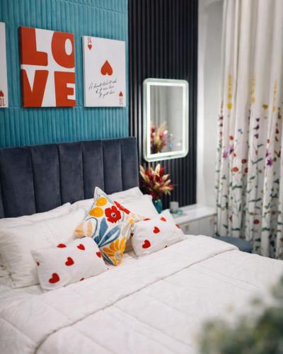 a bedroom with a white bed with pillows on it at Rizz Santorini Apartment in Negombo