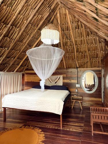 a bedroom with a bed in a wooden house at Chavez Eco Beach Camping and Cabañas in Tulum