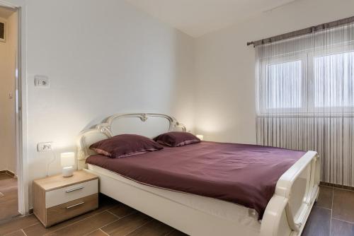 a bedroom with a large bed with purple sheets at David in Mali Lošinj