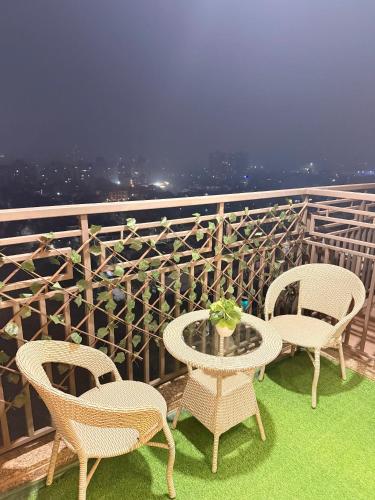 three chairs and a table on a balcony with a view at Hazelnut -Expo India centre in Greater Noida