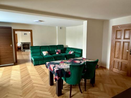 a living room with a green couch and a table at Peter House in Nowy Targ