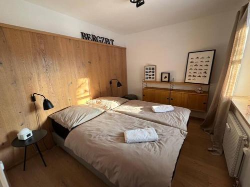 a bedroom with a bed with two towels on it at Achentaler Auszeit in Schleching