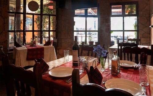 a dining room with a table with chairs and windows at Hotel Balevurov in Sandanski