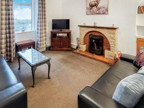 a living room with a couch and a fireplace at Culquhasen in Gillespie
