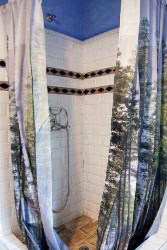 a shower with blue and white shower curtains in a bathroom at Mas els Terrats in Susqueda