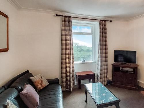 a living room with a couch and a window at Culquhasen in Gillespie