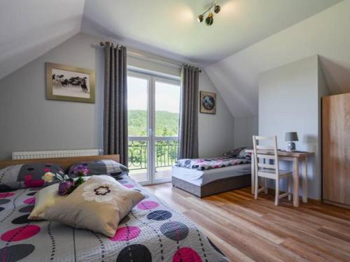a bedroom with a bed and a desk and a window at Pod Stokiem in Lubomierz