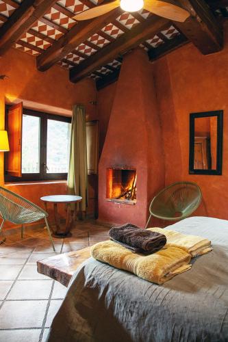 a bedroom with a fireplace and a bed in a room at Mas els Terrats in Susqueda