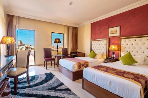 a hotel room with two beds and a desk at P Quattro Relax Hotel in Wadi Musa