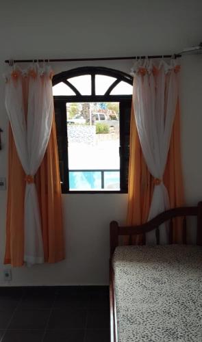 an open window with curtains in a bedroom at Suíte da Lagoa in Araruama